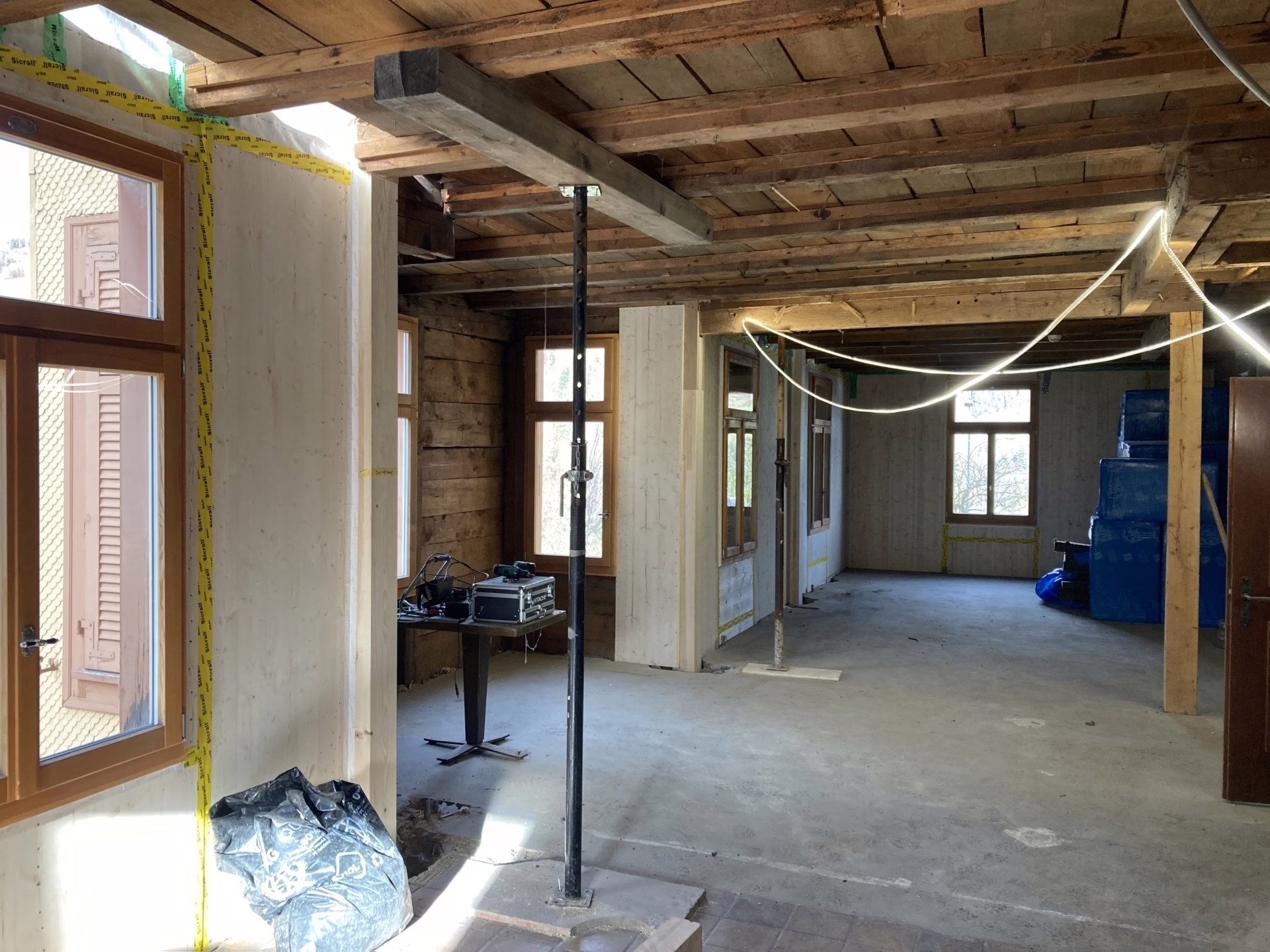Vertikaler Lastabtrag über den Einbau neuer Hauptstützen – ein minimalinvasiver Eingriff im Bestand. Die Pfosten verschwinden im Endzustand hinter der Holzbekleidung.